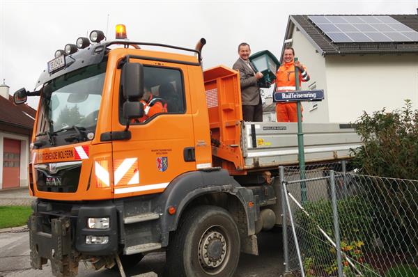 Ein paar Männer, die auf einem großen orangefarbenen Lastwagen stehen